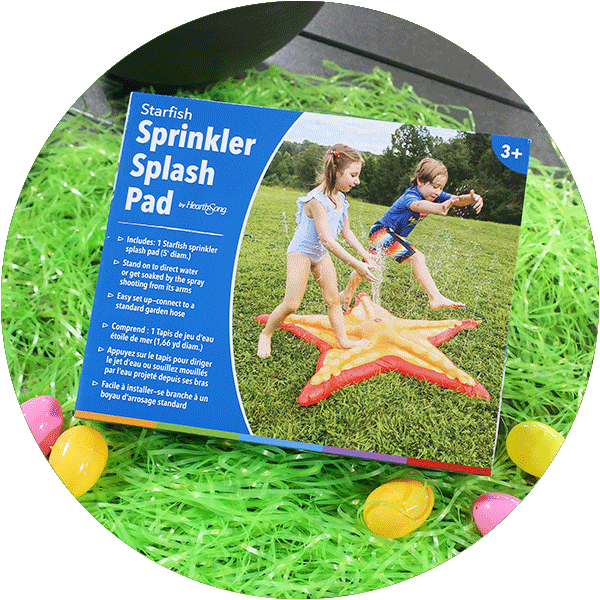 A box containing an orange starfish sprinkler splash pad, laying on green easter grass with colorful eggs around it.